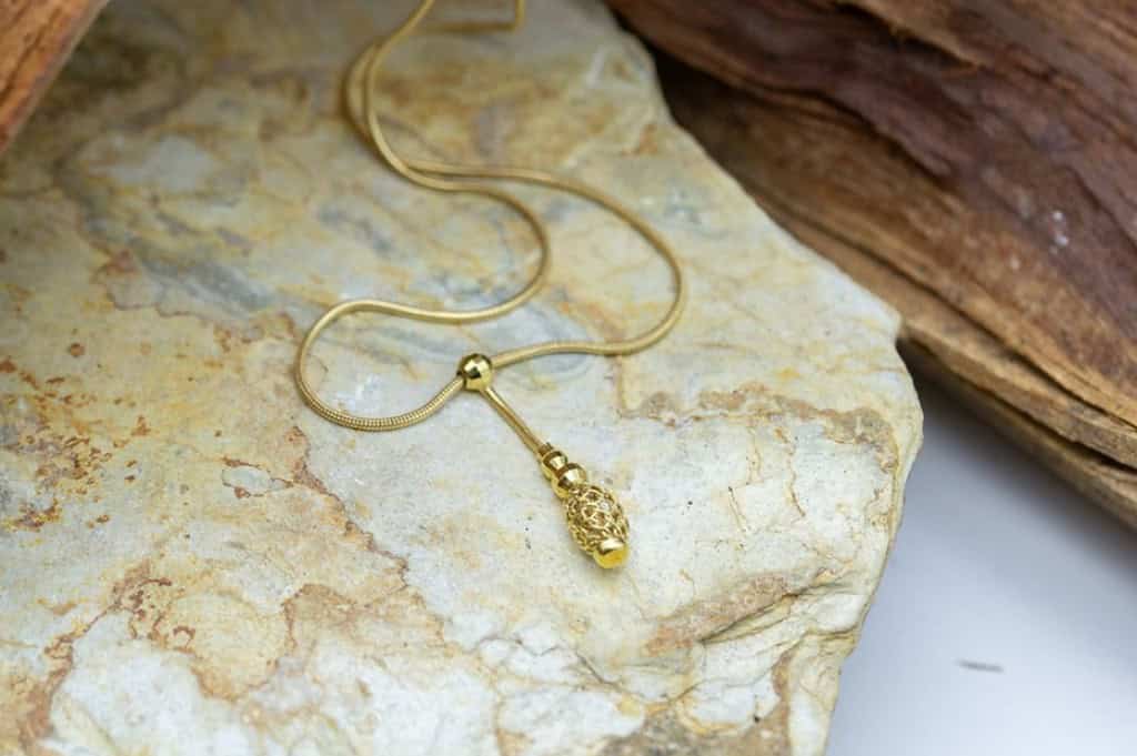 Cordón de oro con colgante de diseño elaborado y elegante.