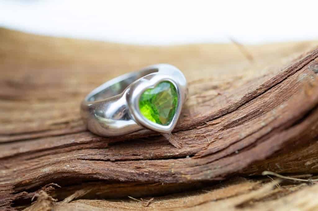 Sortija con piedra de color verde y talla corazón.