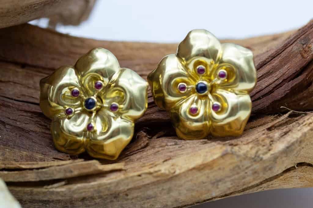 Lujosos pendientes de flor en oro con gemas, delicados y elegantes.